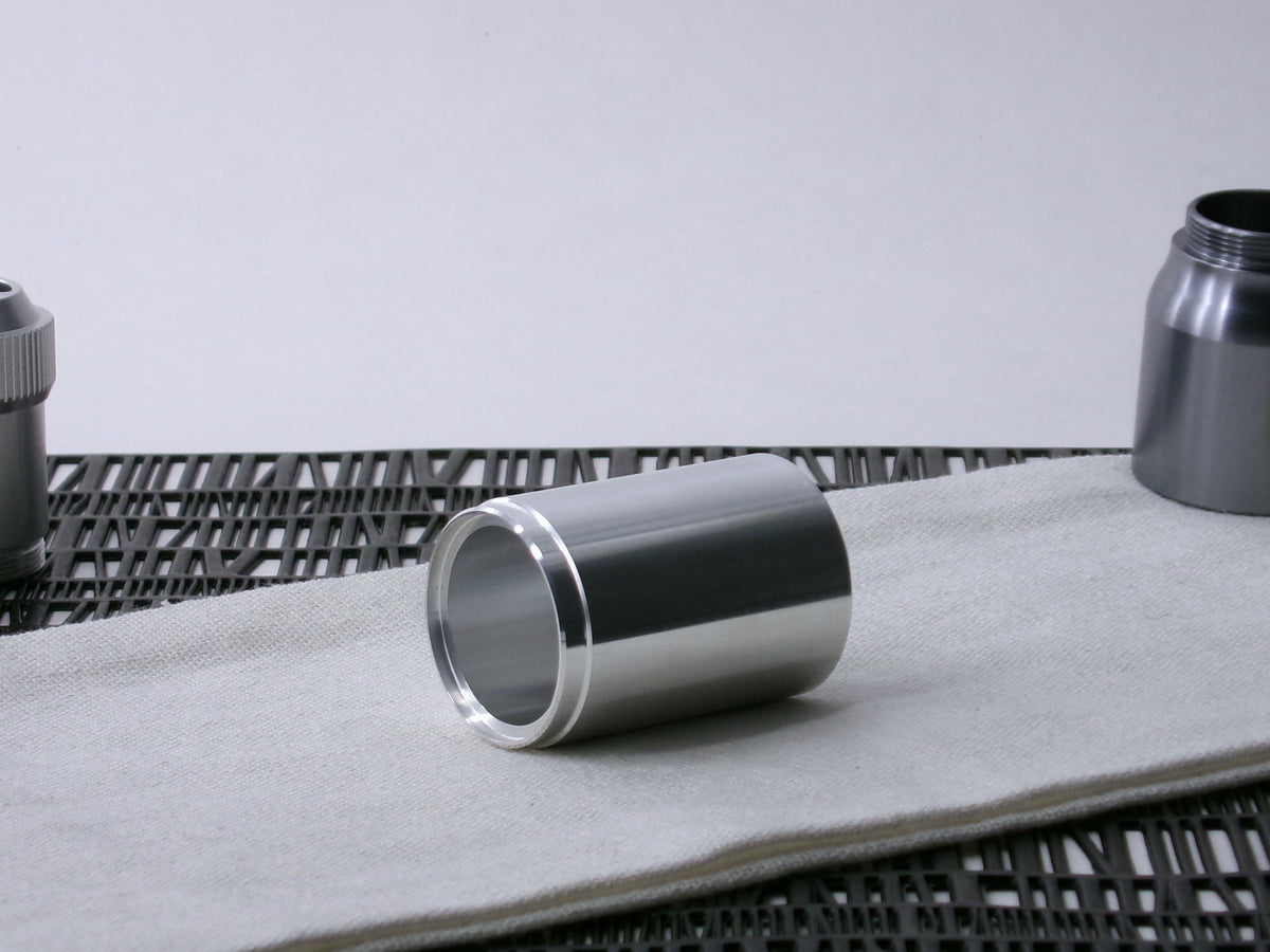 A stepped, VHC-compatible, lightsaber Accent Sleeve sits 3/4 view showing shim-sert, on a cloth.