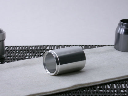 A stepped, VHC-compatible, lightsaber Accent Sleeve sits 3/4 view showing shim-sert, on a cloth.