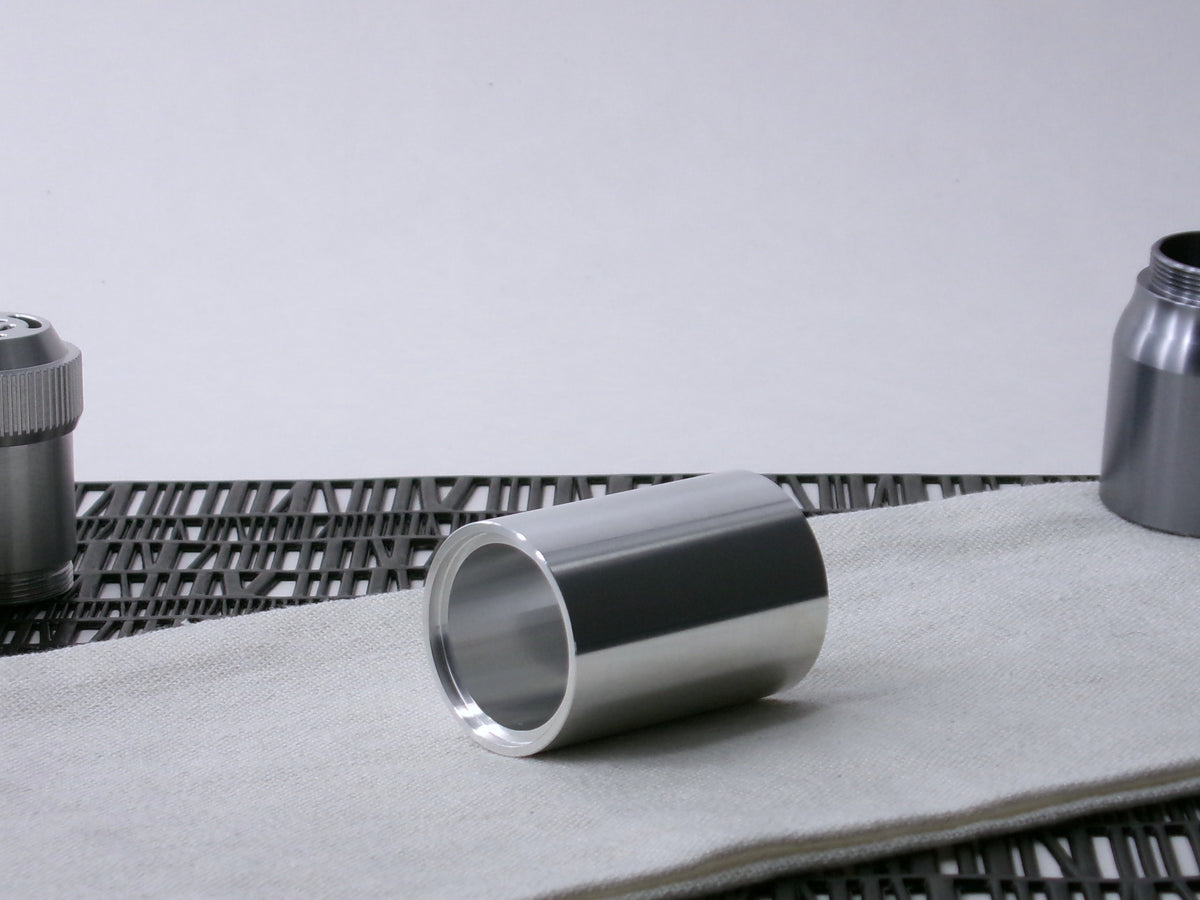 A simple, VHC-compatible, lightsaber Accent Sleeve sits 3/4 view showing shim-sert, on a cloth.