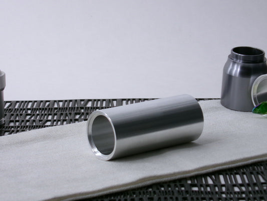 A simple, VHC-compatible, lightsaber Accent Sleeve sits 3/4 view showing shim-sert, on a cloth.
