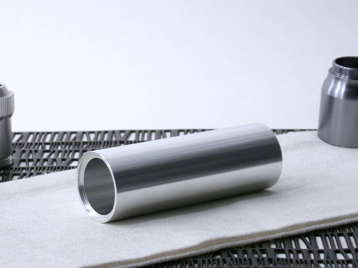 A simple, VHC-compatible, lightsaber Accent Sleeve sits 3/4 view showing shim-sert, on a cloth.