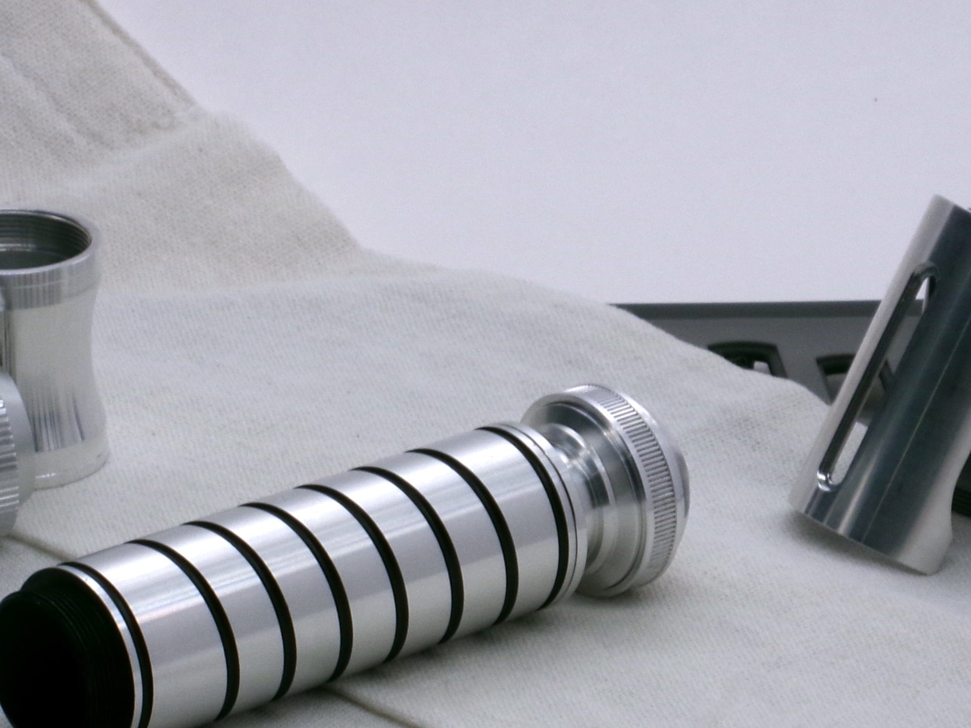 A versatile, aluminum male-to-male hybrid adapter compatible with VHC lightsabers, installed on a VHC grip with Accent Ring Type 1.1 and Pommel Cap Type 1, 3/4 view.