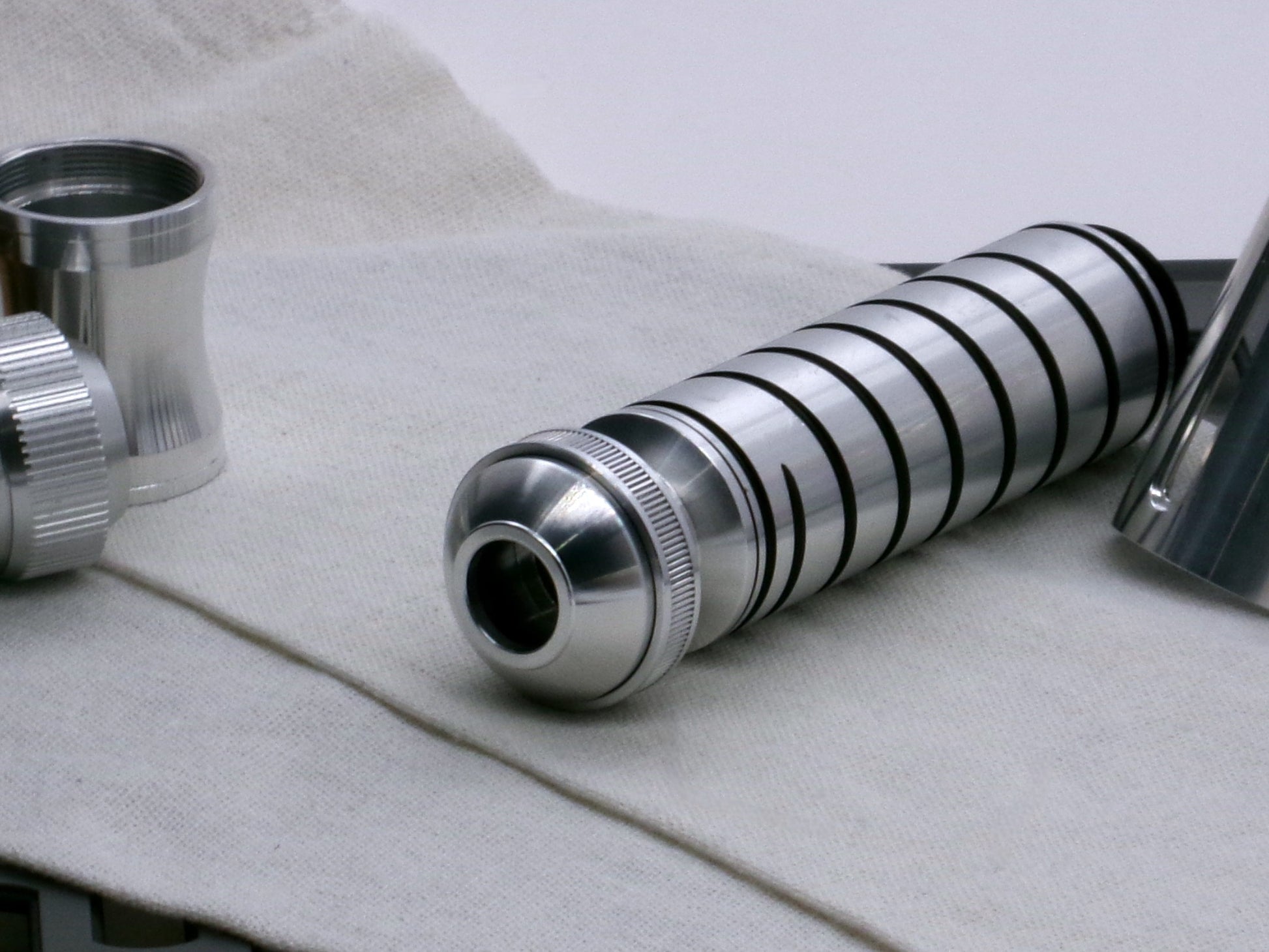 A versatile, aluminum male-to-male hybrid adapter compatible with VHC lightsabers, installed on VHC grip and Pommel Cap Type 1, Accent Ring Type 1.1, 3/4 view.