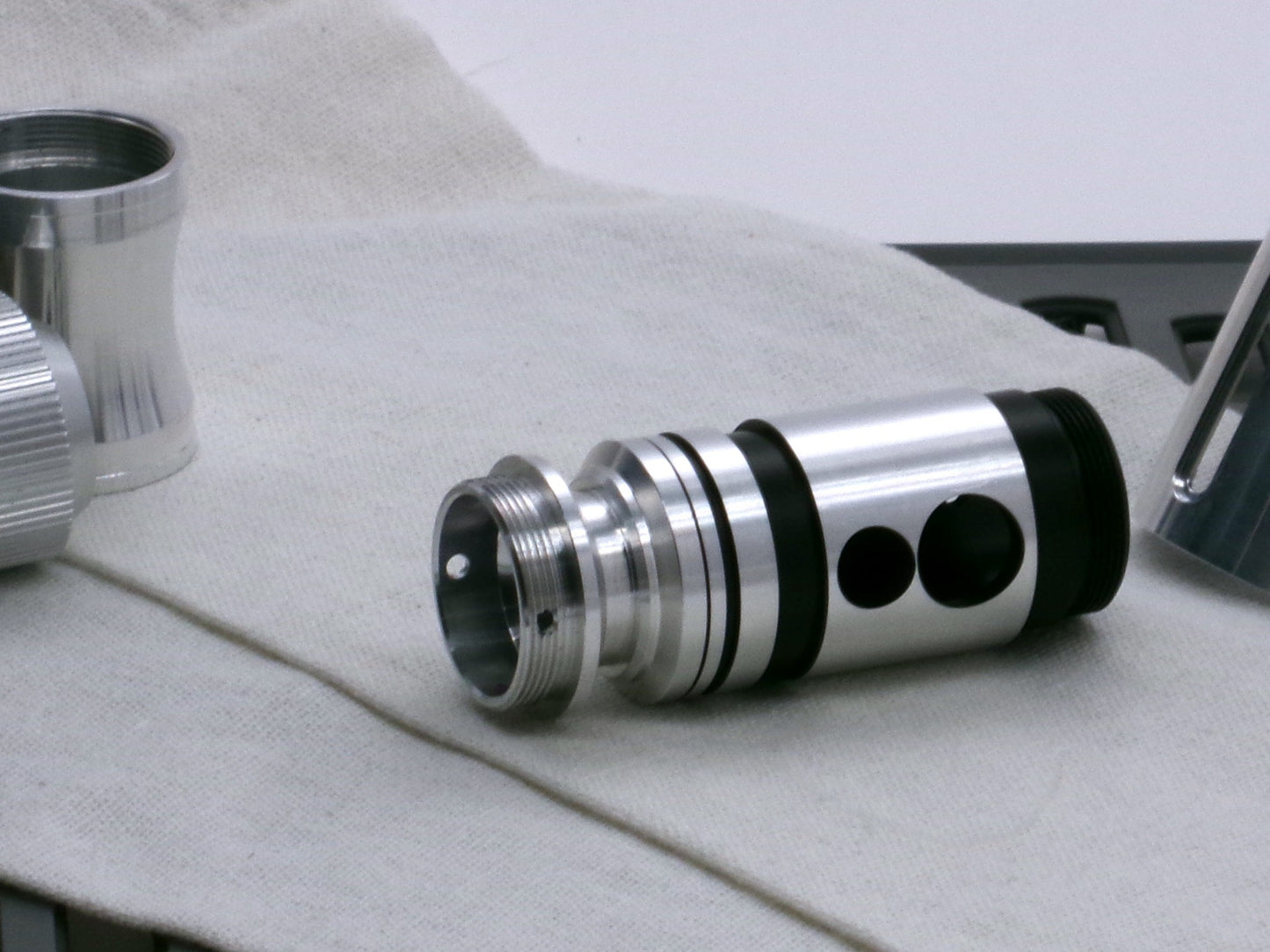 A versatile, aluminum male-to-male hybrid adapter compatible with VHC lightsabers, installed in a VHC switch.