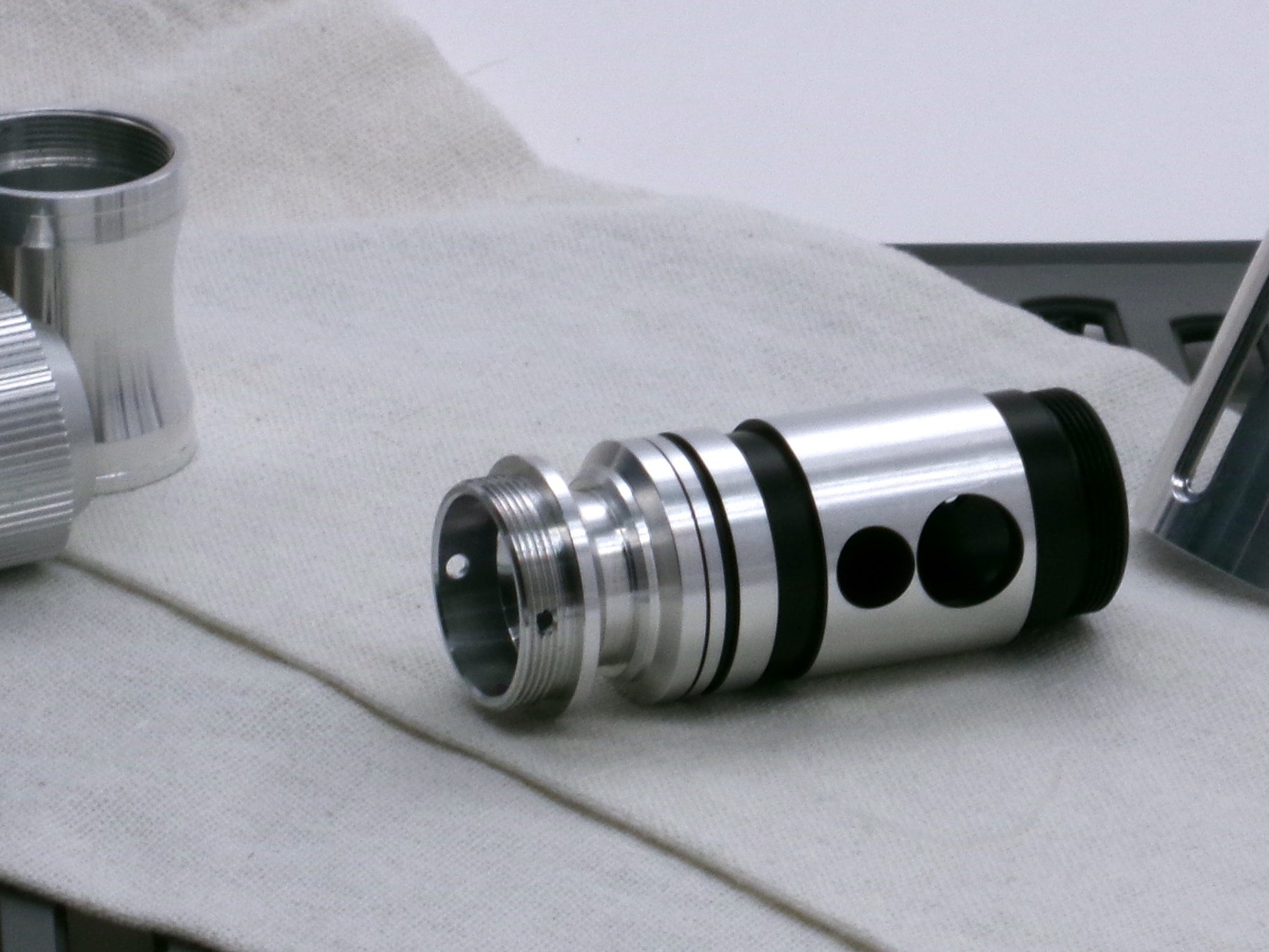 A versatile, aluminum male-to-male hybrid adapter compatible with VHC lightsabers, installed in a VHC switch.