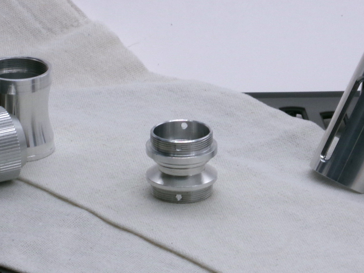 A versatile, aluminum male-to-male hybrid adapter compatible with VHC lightsabers, standing tall.