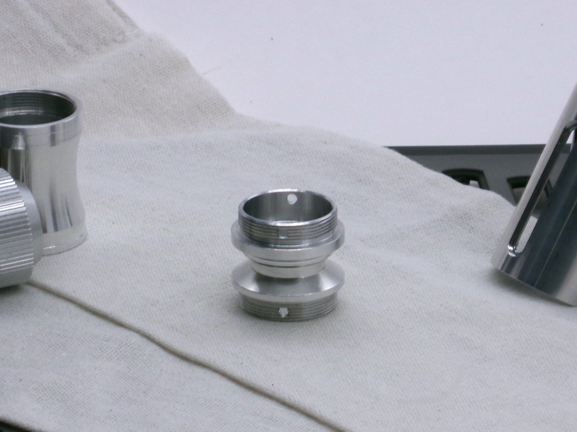 A versatile, aluminum male-to-male hybrid adapter compatible with VHC lightsabers, standing tall.
