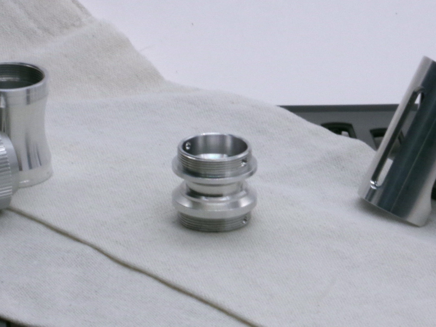 A versatile, aluminum male-to-male hybrid adapter compatible with VHC lightsabers, standing tall.