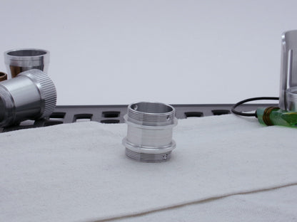 Male threaded adapter for VHC lightsabers resting vertically on cloth.