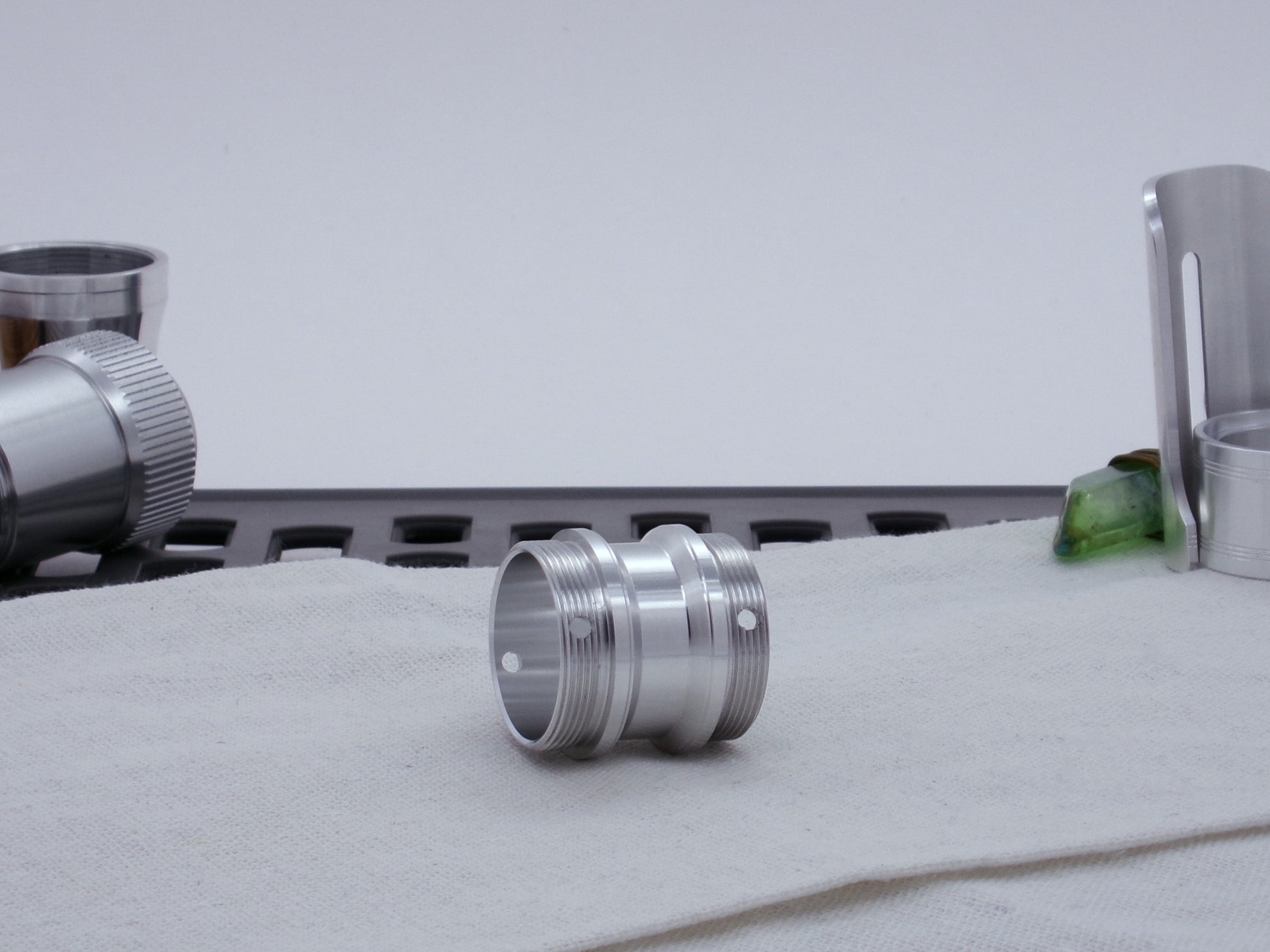 Male threaded, angled choke adapter for VHC lightsabers resting on cloth, three-quarter view angled left.