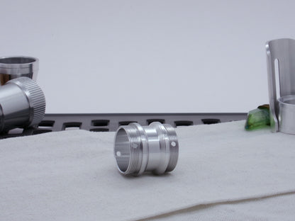 Male threaded, angled choke adapter for VHC lightsabers resting on cloth, three-quarter view angled left.