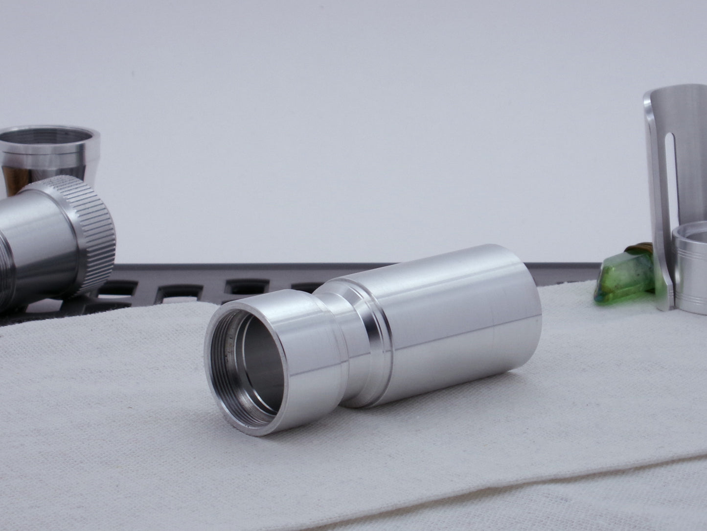 Male threaded, angled choke adapter for VHC lightsabers installed between two Body Components.  Resting on cloth, three-quarter view angled left.