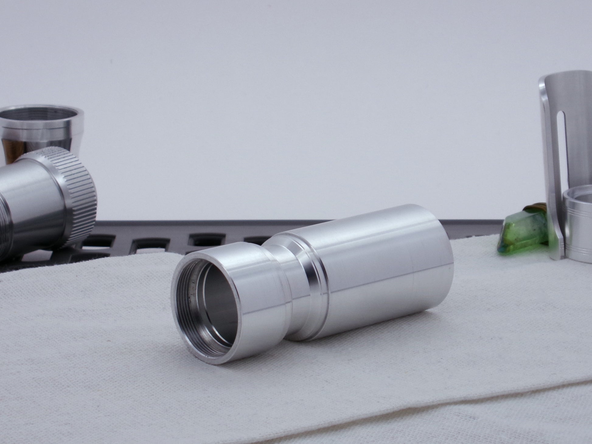 Male threaded, angled choke adapter for VHC lightsabers installed between two Body Components.  Resting on cloth, three-quarter view angled left.