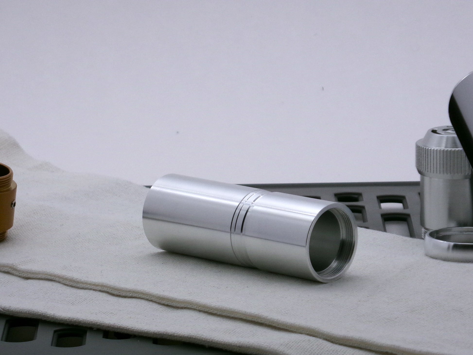 Single aluminum female/female threaded VHC lightsaber body component installed above a Adapter_MM-Type_2; three-quarter view.