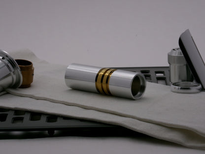 Single aluminum female/female threaded body component installed below a golden ribbed VHC lightsaber component; three-quarter view.