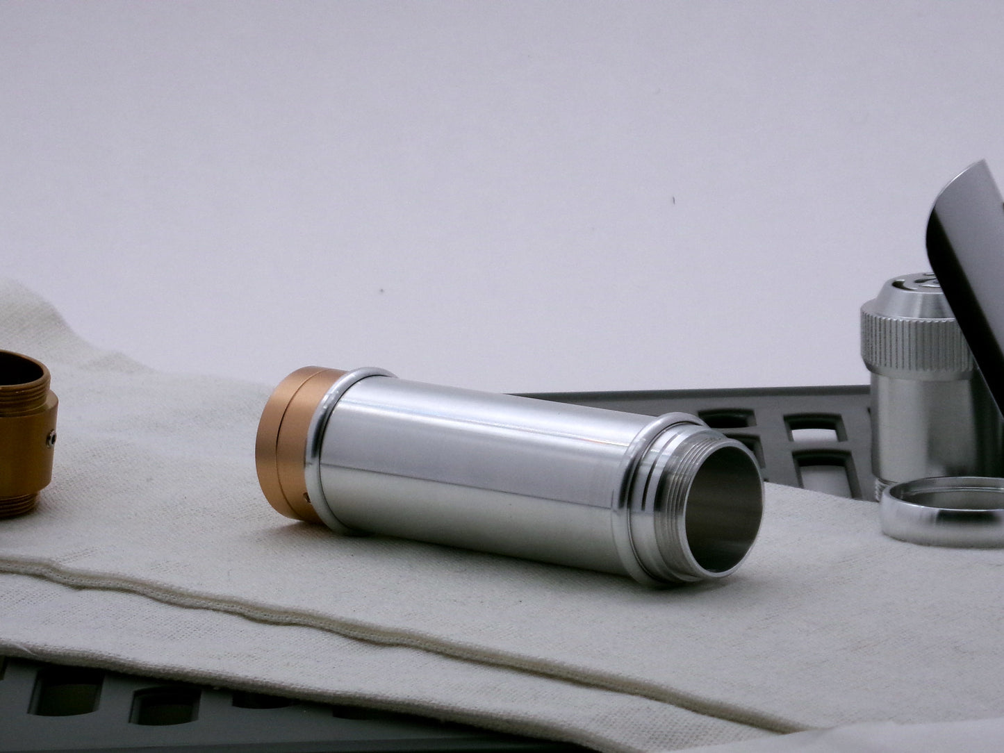 Single aluminum female/female threaded body component for VHC lightsabers combined with Accent rings and Adapters; three-quarter view.