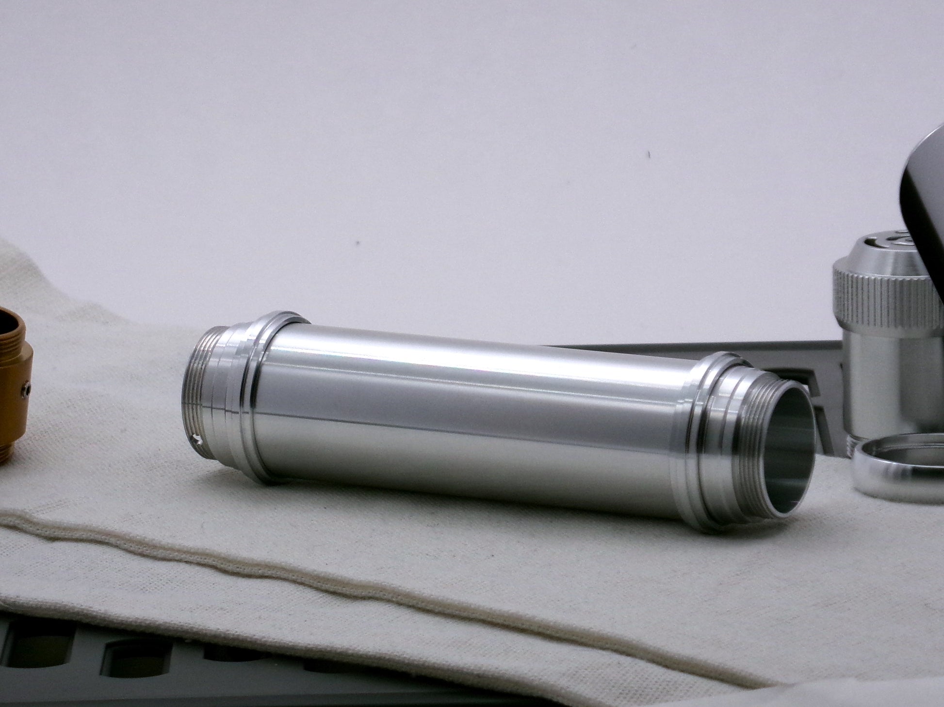 Single aluminum female/female threaded body component for VHC lightsabers combined with Accent rings and Adapters; three-quarter view.