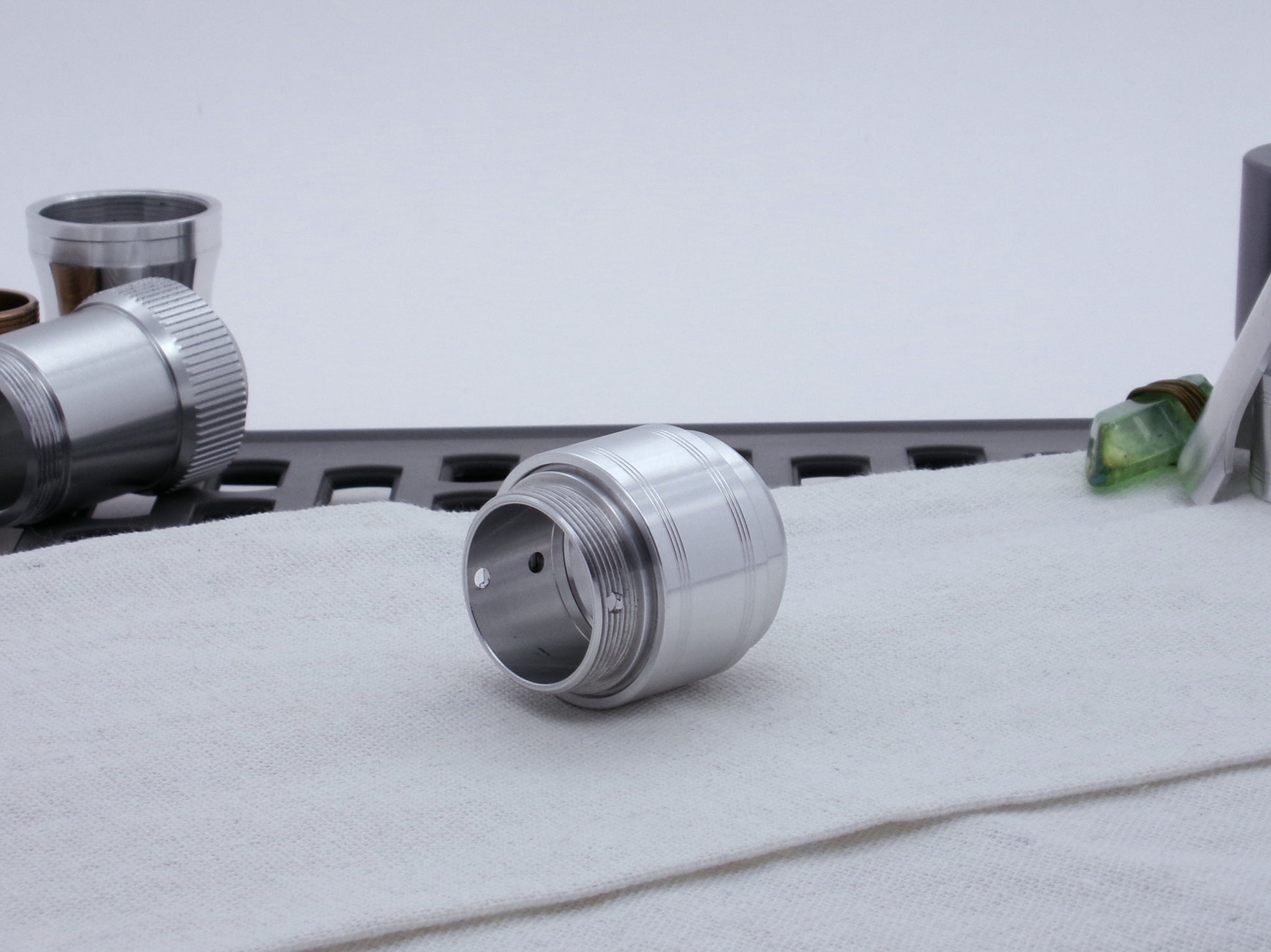 Assembled Pommel Assembly Kit for VHC lightsabers, sitting on cloth among lightsaber parts, three quarter view top.