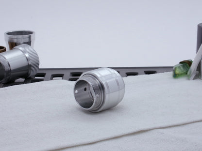 Assembled Pommel Assembly Kit for VHC lightsabers, sitting on cloth among lightsaber parts, three quarter view top.