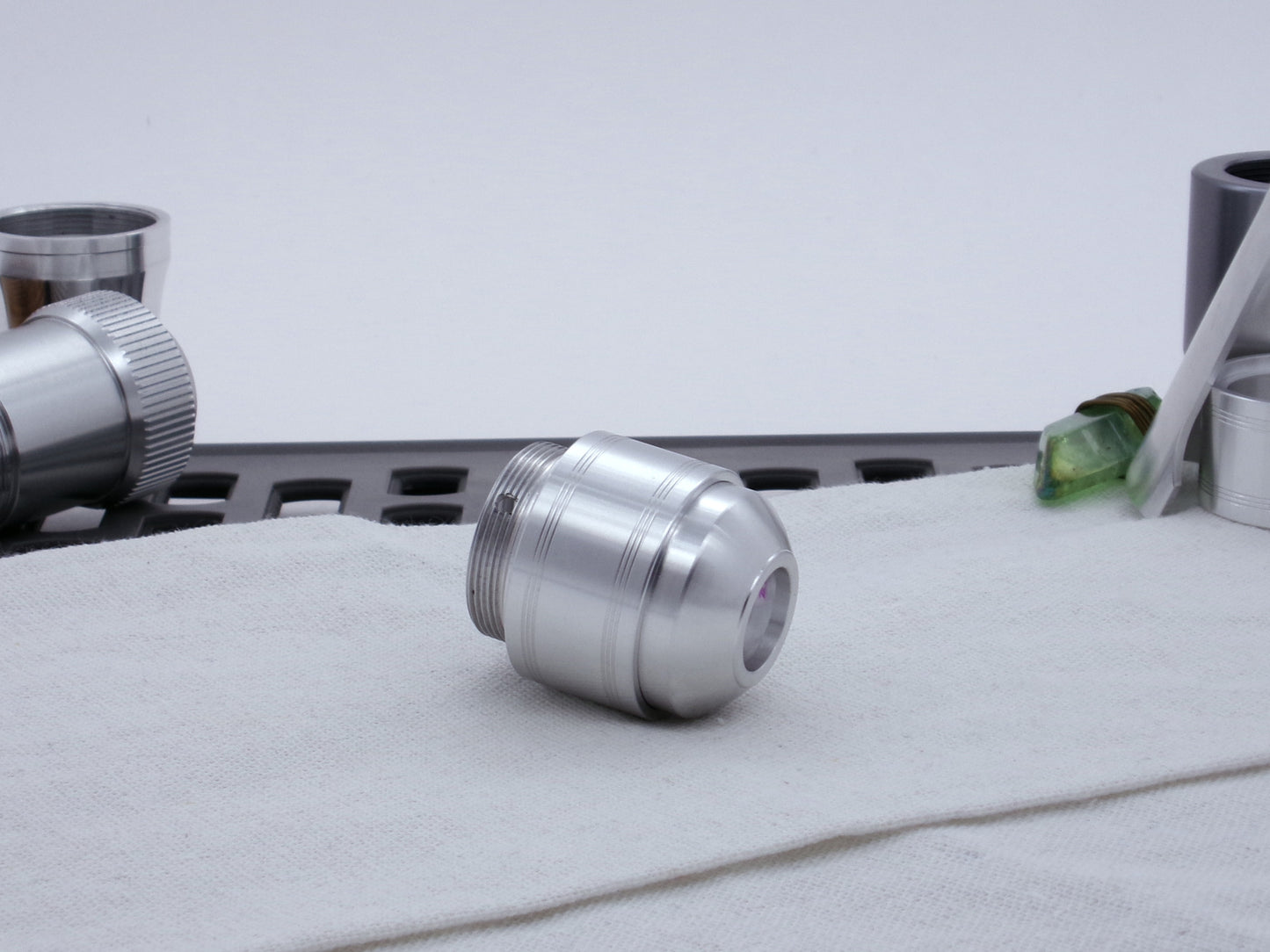 Assembled Pommel Assembly Kit for VHC lightsabers, sitting on cloth among lightsaber parts, three quarter view bottom .