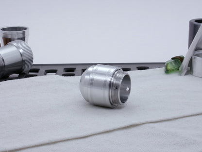 Assembled Pommel Assembly Kit for VHC lightsabers, sitting on cloth among lightsaber parts, three quarter view bottom.