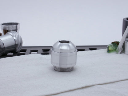 Assembled Pommel Assembly Kit for VHC lightsabers, sitting vertically on cloth among lightsaber parts.