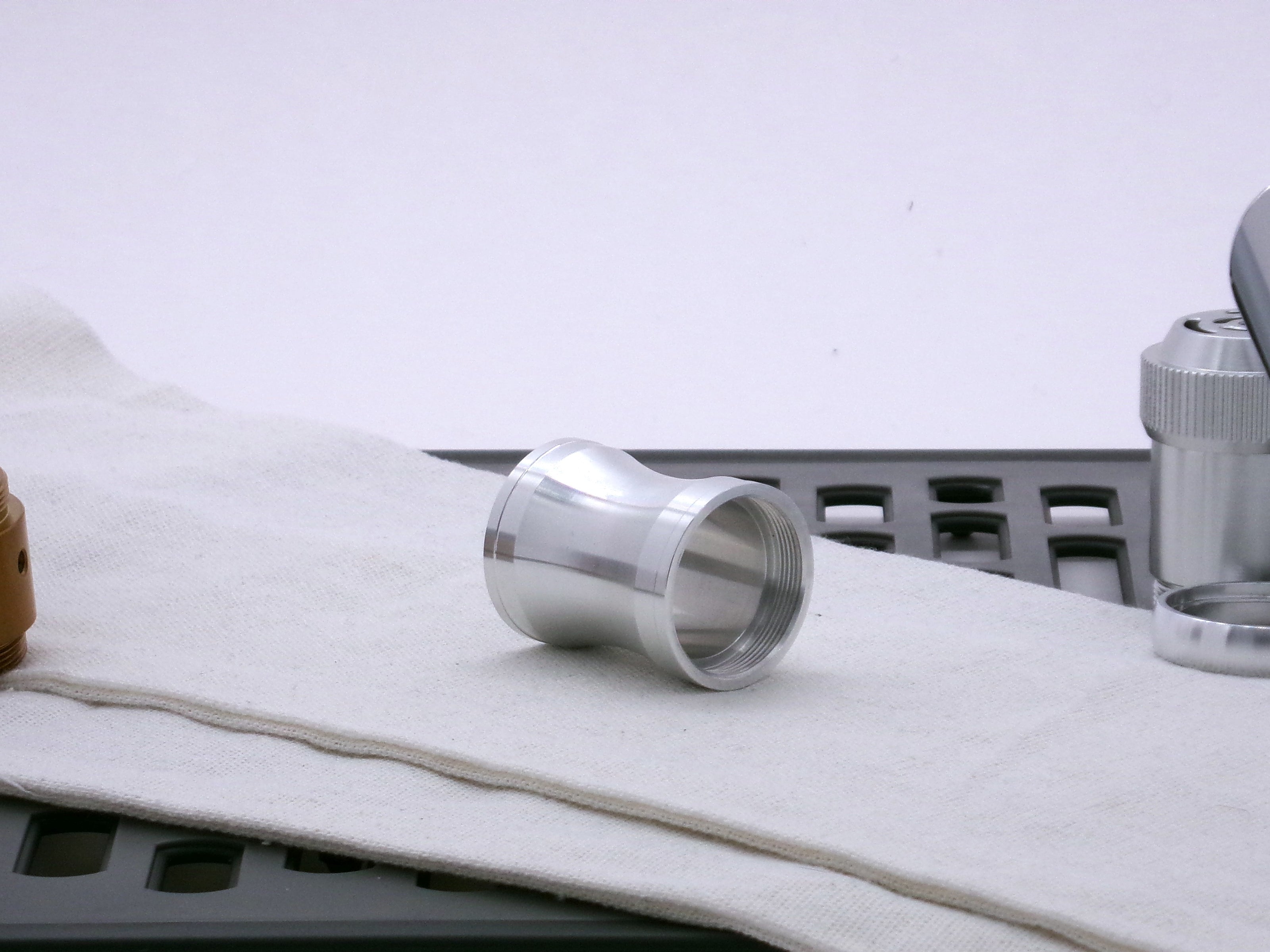 Aluminum female/female threaded curved grip choke for VHC lightsabers; three-quarter view.