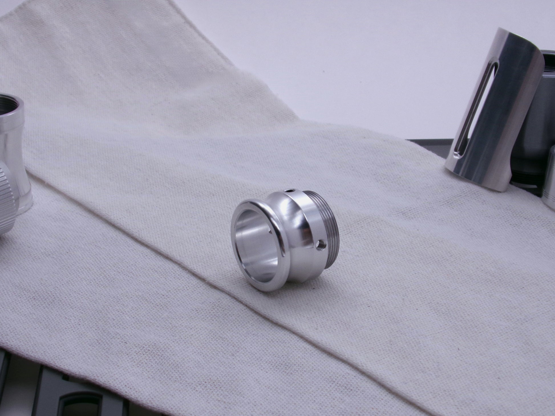 An emitter tip, 3/4 view resting on a coarse cloth.