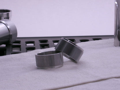 Pair of VHC compatible knurled body segments sitting askew on a cloth.