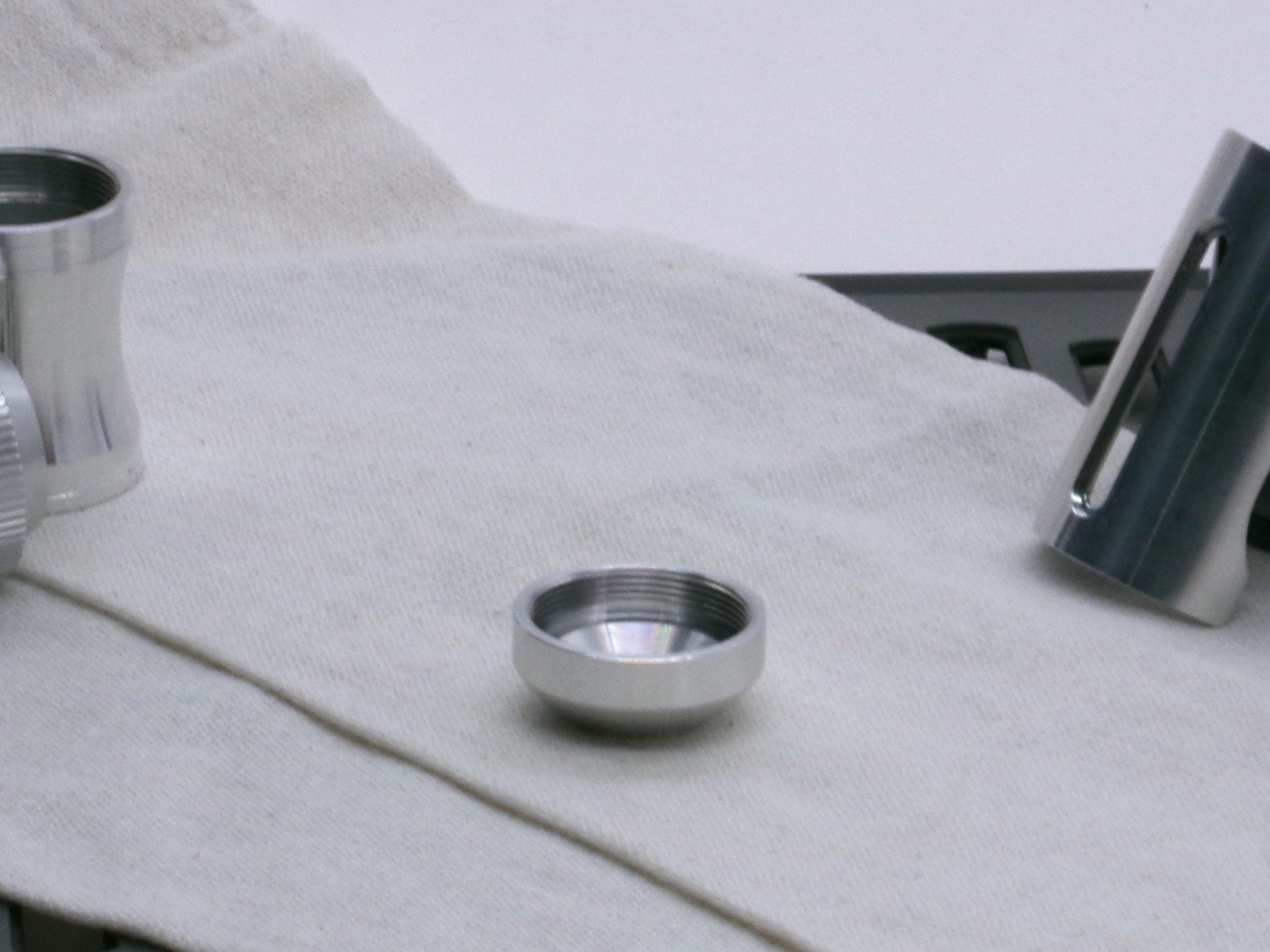 A basic, aluminum female-threaded pommel.  Shows thread profile and internal chamfer while lying flat.