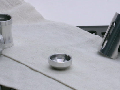 A basic, aluminum female-threaded pommel.  Shows thread profile and internal chamfer while lying flat.