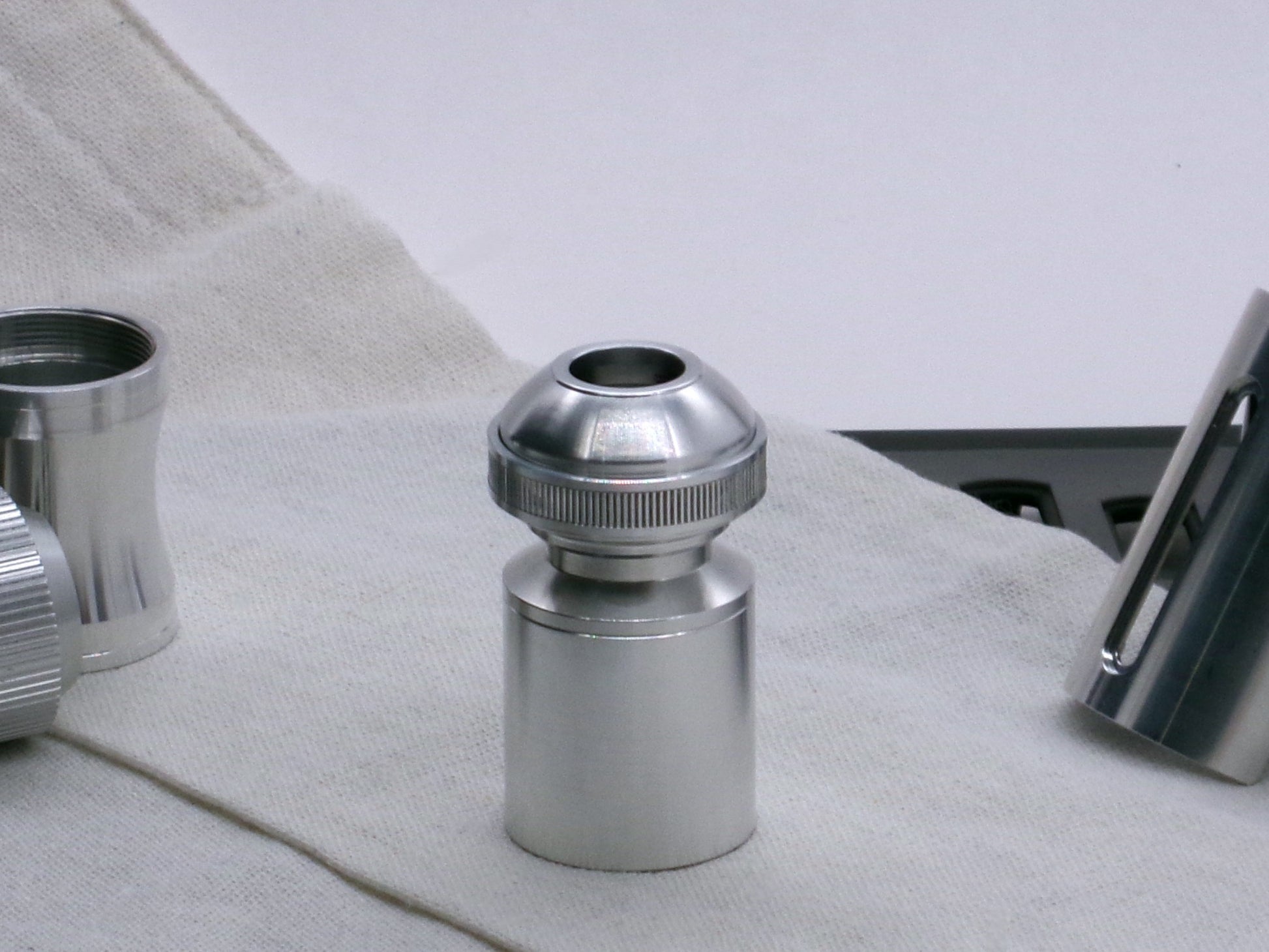 A basic, aluminum female-threaded pommel installed on Adapter MM Hybrid Type 1 with Accent Ring Type 1.1 all installed on a Body Segment Type 2, standing vertical.